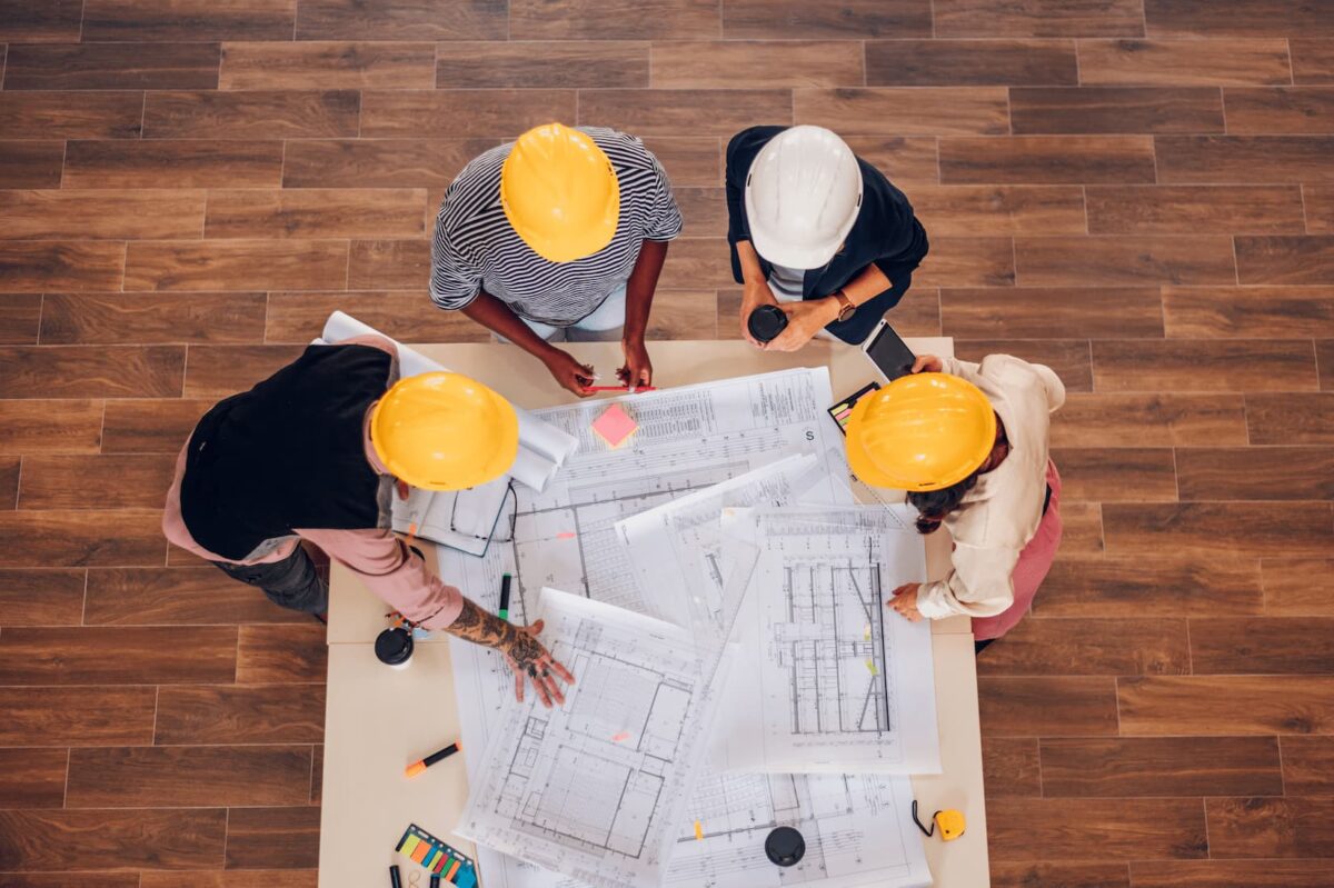 workers looking at construction blueprints on a work table